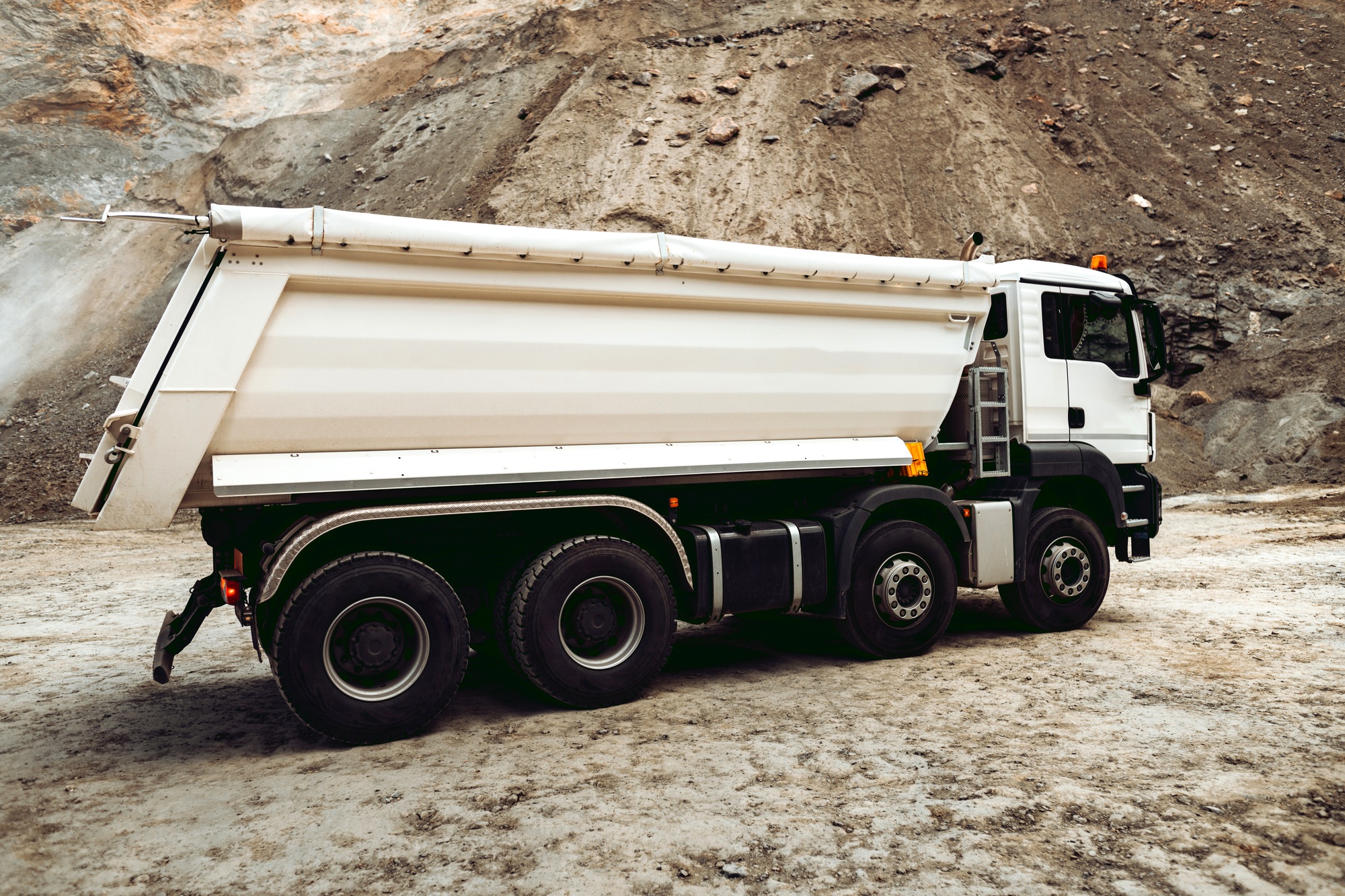 Dumper trucks unloading gravel on highway construction site